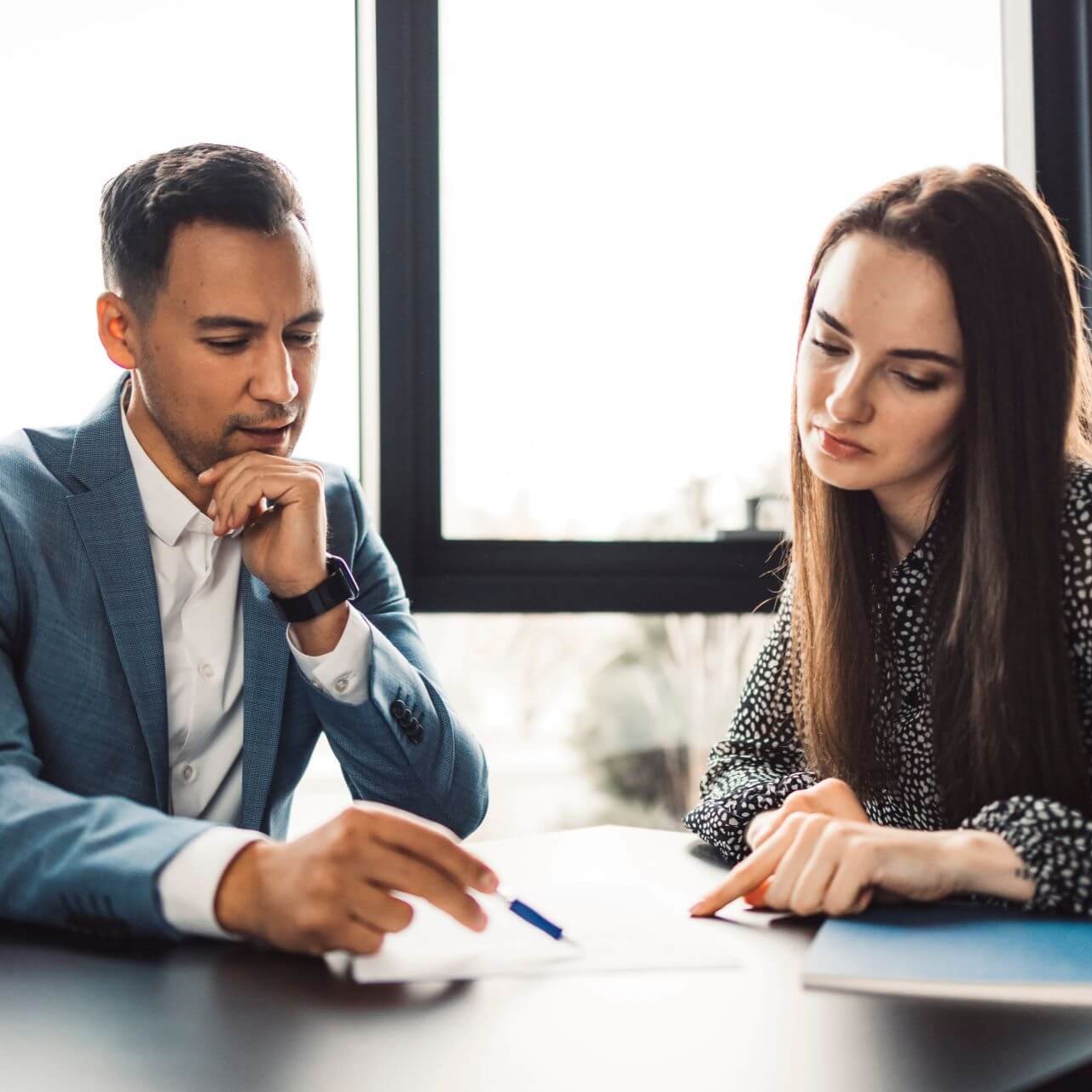 Two colleagues reviewing a document in a meeting
