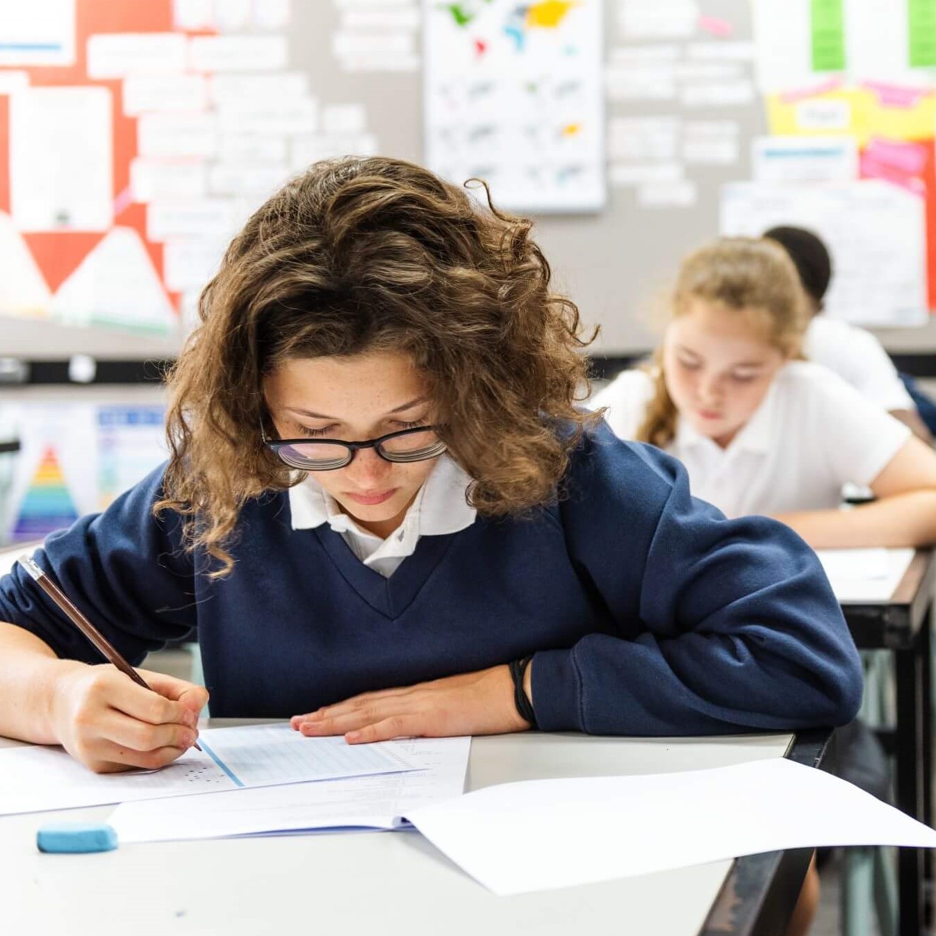 Focused students in a classroom writing and taking an exam