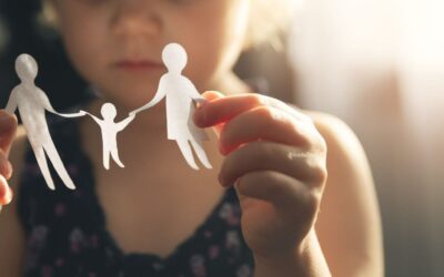 little girl with family of cut out paper dolls in hands