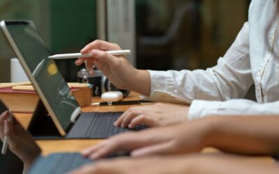 Two colleagues at laptops working together